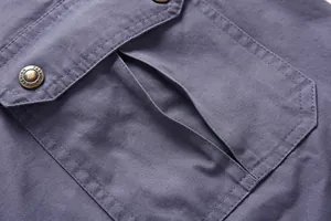 Detalle de primer plano del bolsillo con solapa de pantalones cargo y botón decorativo