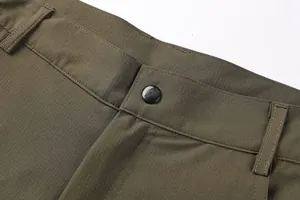 Close-up detail of men's olive green outdoor cargo shorts showing waistband and ripstop fabric