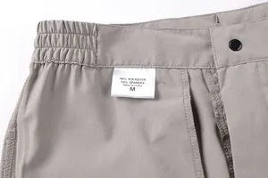 Detail of men's cargo pants label showing 90% polyester 10% spandex material