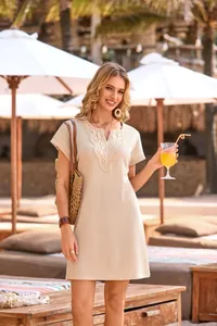 Close-up of beige waffle knit dress with intricate lace V-neck detailing on a model