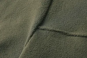 Primo piano della trama del tessuto in pile polare verde militare per felpa invernale da uomo