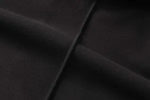 Primo piano del tessuto in pile nero che mostra texture e dettagli cuciture per felpa tattica.