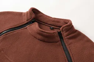 Dettaglio della felpa tattica da uomo in pile marrone con collo alto e zip nere.