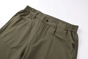 Close-up detail of military green tactical pants waistband featuring elastic sides and pockets