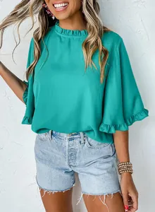 Detail view of a teal summer blouse featuring elegant ruffle neckline and half sleeves.