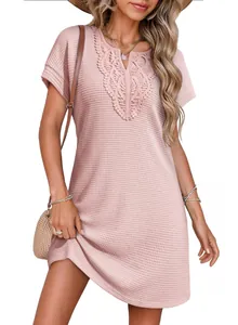Detail view of a pink waffle-knit dress with delicate floral lace trim at the V-neckline