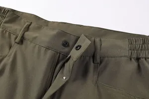 Detail view of army green cargo shorts waist featuring snap button and zipper fly