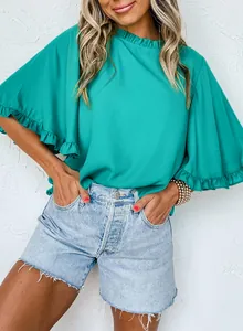 Close-up view of a vibrant teal summer blouse featuring an elegant ruffled collar and bell sleeves