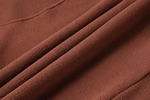 Primo piano della texture del tessuto in pile marrone caldo per felpa tattica da uomo.