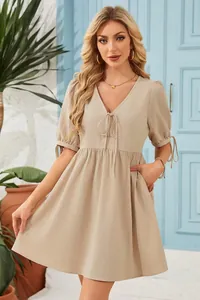 Fashionable beige V-neck dress featuring puff sleeves and a front tie detail for summer wear
