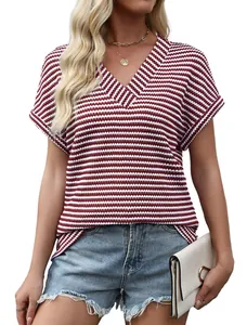 Dettaglio del top in maglia a righe rosse e bianche con scollo a V e trama a nido d'ape