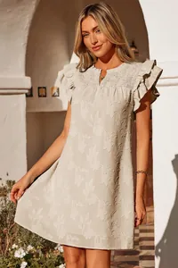 Model wearing a V-neck ruffle sleeve mini dress with smocked chest and floral texture