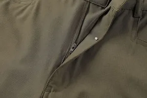 Close-up of high-quality metal zipper and ripstop fabric on olive green cargo pants