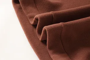 Primo piano del pesante materiale in pile marrone di una felpa tattica da uomo.