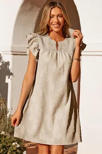 Detailed view of sage green floral mini dress with ruffled sleeves and smocked neckline