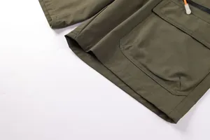 Close-up of olive green outdoor cargo shorts showing pocket detail and textured fabric.