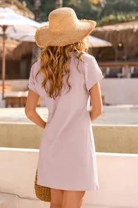Back view of a lavender waffle knit short sleeve mini dress in a resort setting