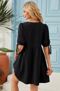 Detailed back view of a black V-neck dress with stylish tie-up puff sleeves