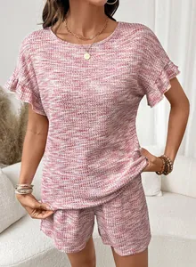 Dettaglio di un set in maglia waffle rosa con eleganti maniche a volant per donne