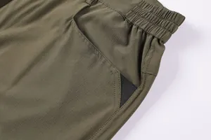 Close-up of olive green cargo shorts featuring ripstop fabric and mesh pocket detail.