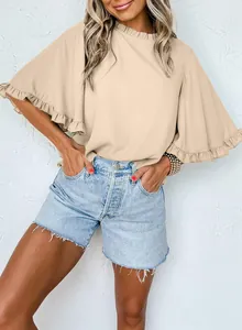 Detail view of a beige ruffle neck blouse with flared flutter sleeves on a model