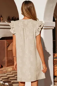 Back detail of beige floral jacquard dress with ruffled short sleeves and feminine silhouette.