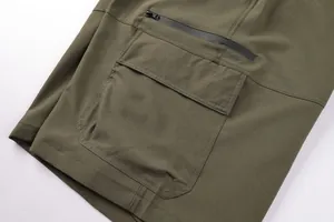 Detail of army green men's cargo shorts featuring waterproof zipper and large pocket.