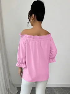 Vue arrière d'une blouse rose à épaules dénudées avec des détails féminins de volants