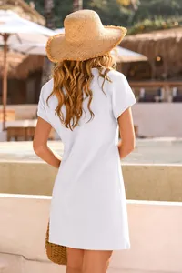 Back view of a white waffle-textured mini beach cover-up dress with a casual straw hat