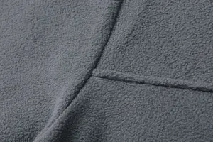 Vista dettagliata della trama del tessuto in pile grigio e delle cuciture sul pullover uomo