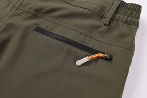 Detailed macro view of the back zipper pocket on men's olive green outdoor hiking shorts