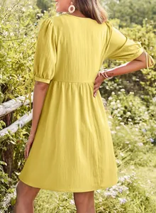 Back view of a yellow puff sleeve dress with tie-up details and high-waisted design.