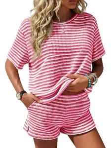 Detail shot of women's pink striped knit two-piece set showing texture and side slit