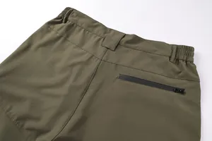 Detail shot of the rear zipper pocket on high-quality olive green tactical cargo pants