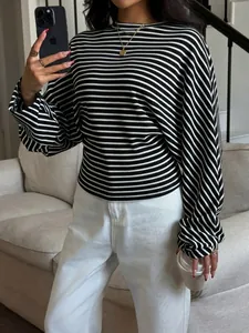 Chic black and white striped batwing sleeve top with round neck in lifestyle setting