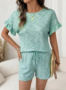 Dettaglio del set due pezzi verde in maglia waffle con maniche a volant e pantaloncini.