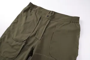 Close-up of waist and pocket stitching on men's army green outdoor cargo shorts