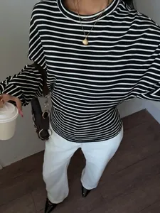 Close-up view of black and white striped crewneck top with batwing sleeves and casual style.