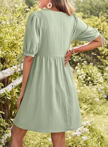Detailed back view of a sage green V-neck dress with puff sleeves and tie details.