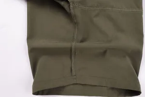 Macro detail showing high-quality stitching on olive green outdoor leisure shorts for men