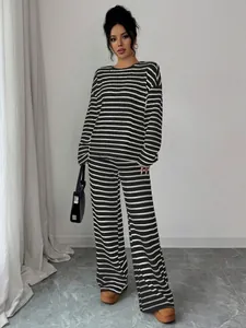Elegante completo due pezzi in maglia a righe bianche e nere con maglia e pantaloni larghi
