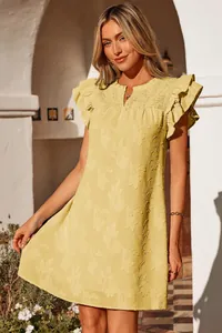 Close-up detail of yellow summer dress featuring smocked yoke and ruffled sleeves