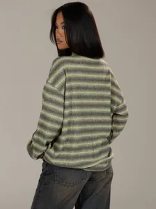 Back view of an oversized striped knit sweater paired with neutral grey denim jeans.