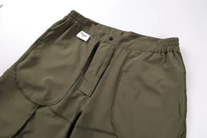 Close-up detail of olive green men's cargo shorts showing waist and fabric texture