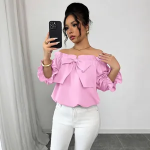 Haut rose chic à épaules dénudées avec un grand nœud et des volants pour un look d'été.