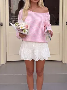 Fashionable pink striped long sleeve knit top paired with white lace mini skirt