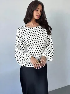 Detailed view of white polka dot satin blouse with lantern sleeves and round neck