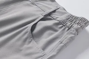 Close-up detail of grey outdoor shorts showing waistband stitching and grid fabric texture