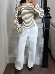 Close-up of a stylish striped batwing sleeve T-shirt paired with white wide-leg trousers