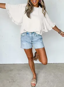 Detailed view of a white round neck blouse with elegant ruffle trim on sleeves